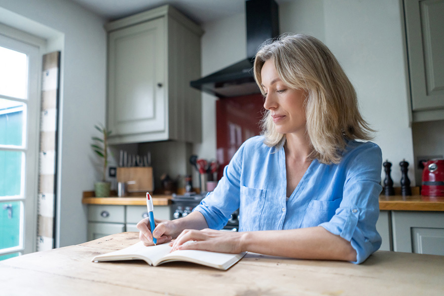 Woman journaling her thoughts practicing self reflection